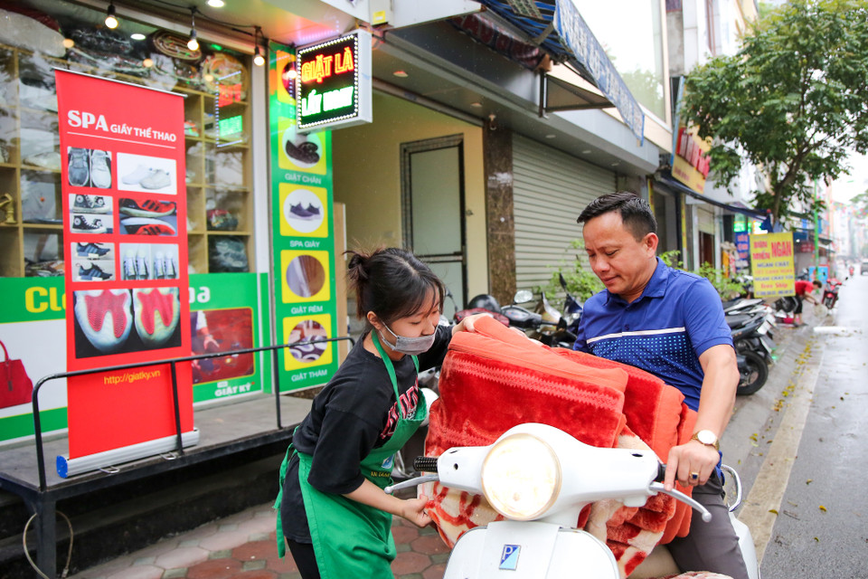Mới đầu, việc giao tiếp với khách hàng gặp khá nhiều khó khăn vì hai bên trao đổi với nhau không hiểu gì. Tuy nhiên, sau khi làm quen, các khách hàng đã biết cách cầm bảng viết ra yêu cầu của mình. (Ảnh: Minh Sơn/Vietnam+)