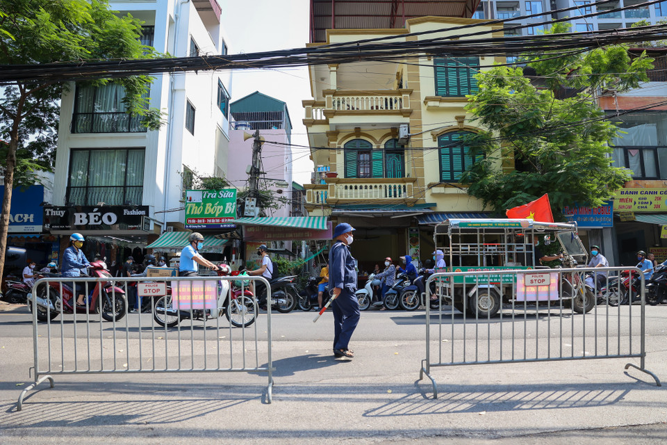 Các tổ tự quản, dân phòng lập các hàng rào cứng và mềm để các thí sinh tham gia kỳ thi đảm bảo giãn cách, giữ gìn trật tự, điều tiết giao thông tại điểm thi trường Trung học Cơ sở Ba Đình (Hà Nội). (Ảnh: PV/Vietnam+)