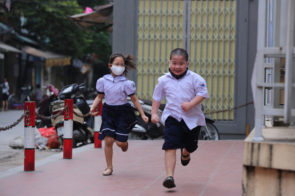 Các học sinh nô đùa trước cổng trường trước giờ vào lớp. (Ảnh: Minh Sơn/Vietnam+)