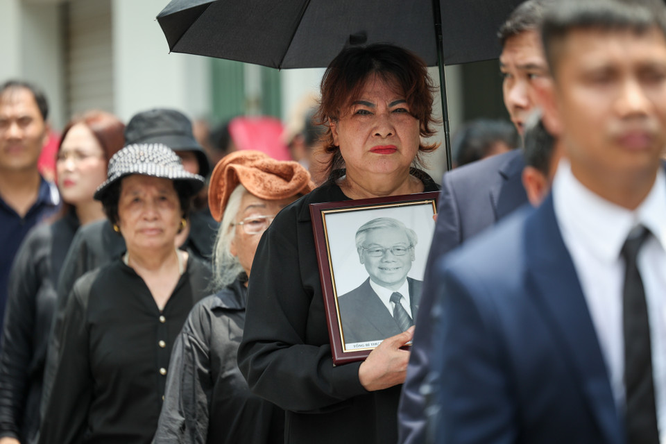 Cô Đặng Thị Mừng đến từ Đông Trù, huyện Đông Anh cùng hàng xóm đã xếp hàng gần 3 tiếng để chờ đến lượt vào viếng. Cô Mừng cho biết mình rất đau buồn và xúc động khi biết tin Tổng Bí thư Nguyễn Phú Trọng mất. Cô cùng mọi người đã chuẩn bị di ảnh đến quê hương Tổng Bí thư để viếng. (Ảnh: Minh Sơn/Vietnam+)