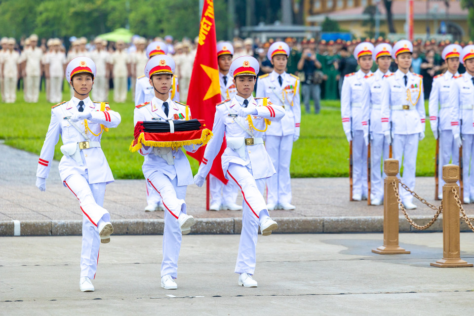 Quốc kỳ được các chiến sĩ buộc thêm dải băng đen theo đúng nghi thức. (Ảnh: Minh Sơn/Vietnam+)