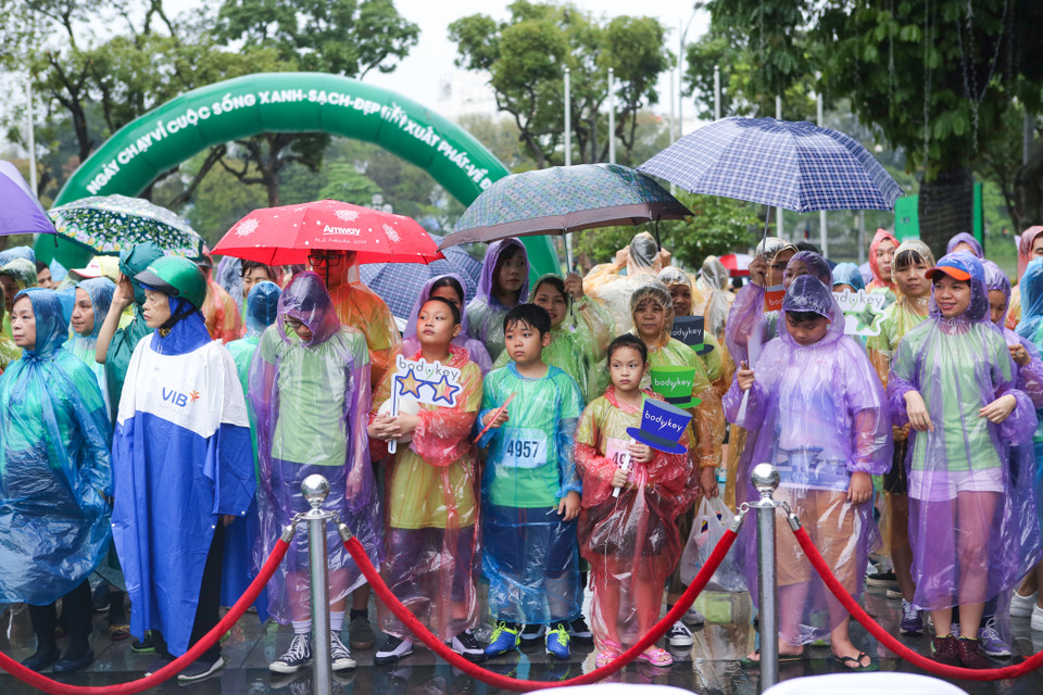 Mặc dù trời mưa tầm tã nhưng từ sáng sớm, hàng ngàn người đã tập trung tại hồ Hoàn Kiếm để sẵn sàng tham gia. (Ảnh: Minh Sơn/Vietnam+)