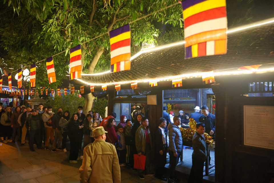 Ngay từ sớm, nhiều người dân đã xếp hàng ngay ngắn chờ đến khoảnh khắc Giao thừa sẽ xin lộc của chùa. (Ảnh: Minh Sơn/Vietnam+)