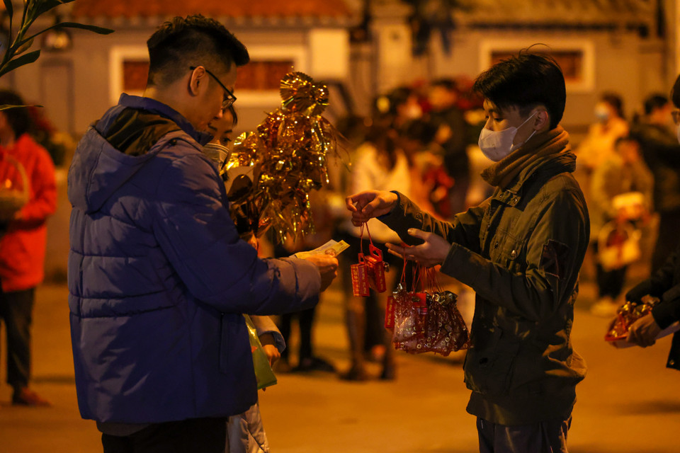 Với quan niệm "đầu năm mua muối, cuối năm mua vôi," sau thời khắc Giao thừa, nhiều người có thói quen mua những gói muối nhỏ hoặc cành lộc để rước may mắn, tài lộc và sự ấm no cho cả năm. (Ảnh: Minh Sơn/Vietnam+)