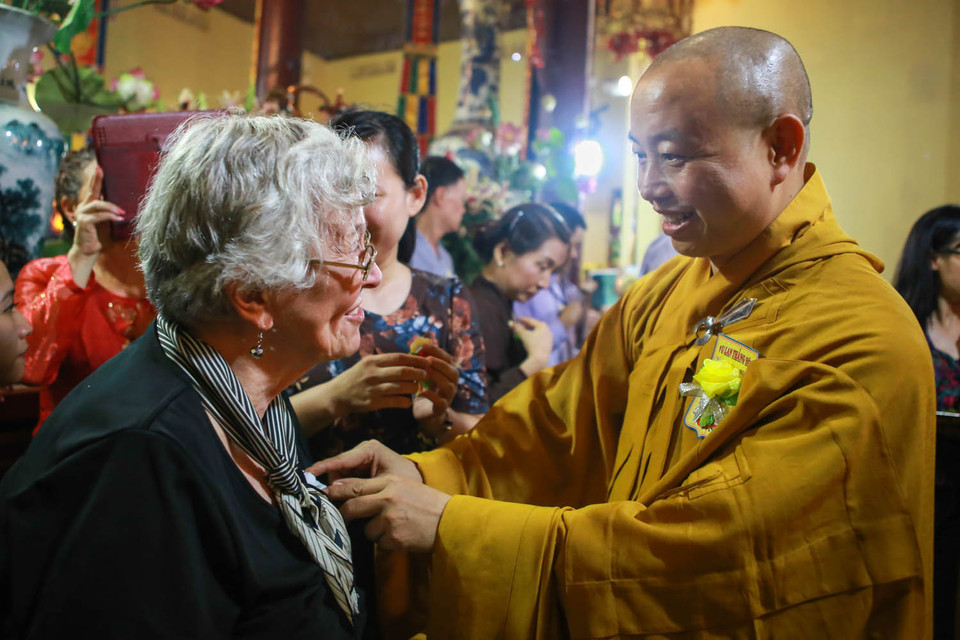 Mẹ ngài Đại sứ Mỹ được Hòa thượng Thích Thanh Nhiễu cài bông hồng trắng. Nghi thức này do thiền sư Nhất Hạnh khởi xướng trong cuốn sách viết năm 1962. (Ảnh: Minh Sơn/Vietnam+)