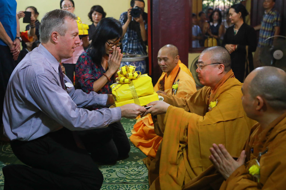 Ngài Ted Osius trao những món quà cho các sư thầy tại chùa Quán Sứ theo đúng nghi lễ. (Ảnh: Minh Sơn/Vietnam+)