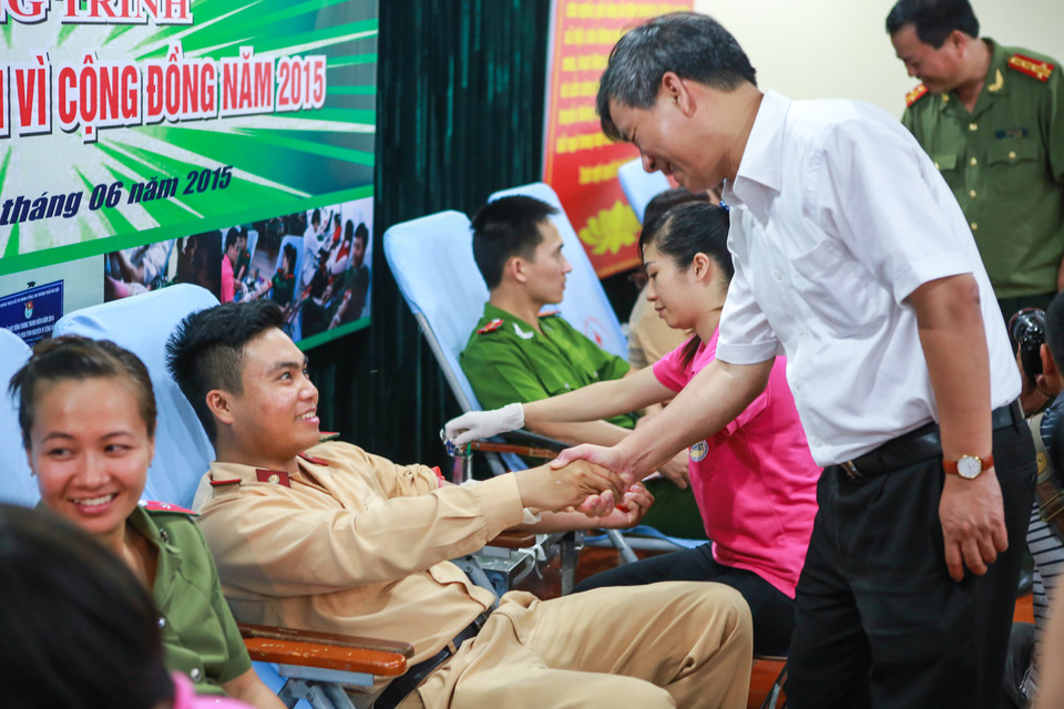 Tiến sỹ Nguyễn Anh Trí, Viện trưởng Viện Huyết học và Truyền máu Trung ương bắt tay thăm hỏi các chiến sỹ công an đang trong quá trình hiến máu. (Ảnh: Minh Sơn/Vietnam+)