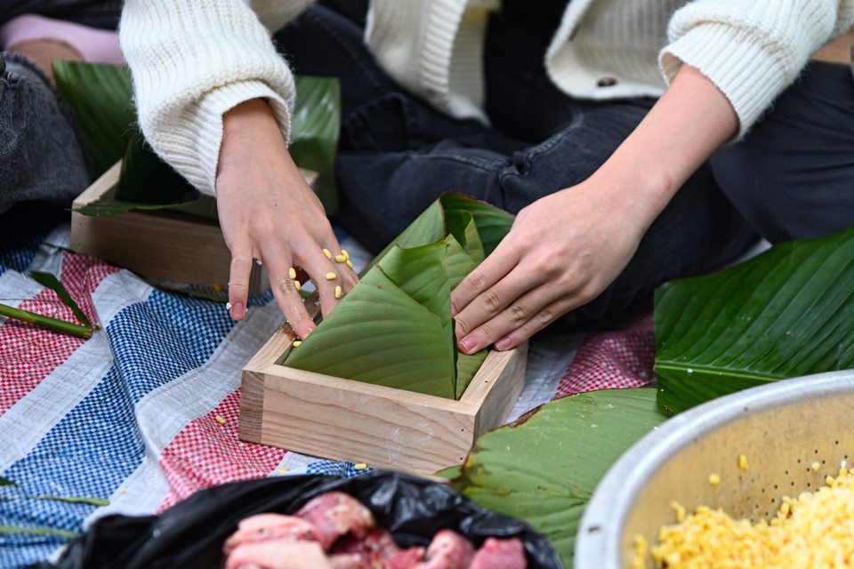 Thành viên trong câu lạc bộ có thể tự làm ra chiếc bánh chưng của riêng mình, đóng góp công sức để tạo ra món quà ý nghĩa trao tặng tới người dân có hoàn cảnh khó khăn. (Ảnh: Minh Sơn/Vietnam+)