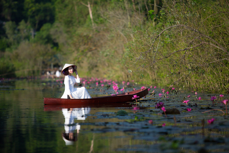 Nhiều du khách chọn thuê đò để có những bộ hình thướt tha giữa dòng nước êm, đồng thời thư thả lượn lờ ngắm 'tiên cảnh' một cách thật yên bình. (Ảnh: Minh Sơn/Vietnam+)