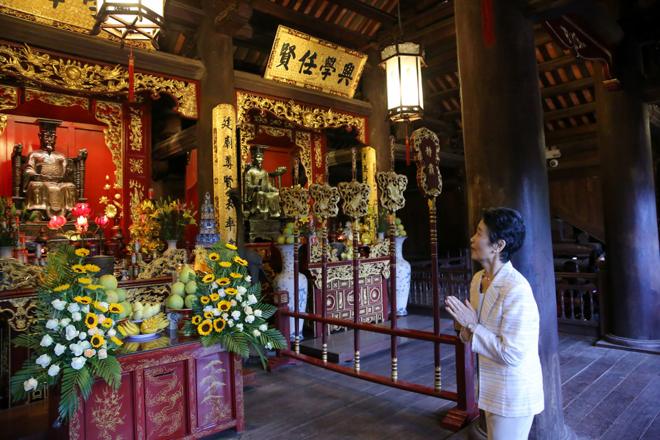 Bà Suga Mariko bày tỏ sự ngưỡng mộ sau khi nghe lời kể của hướng dẫn viên tại đền thờ các vị vua nhà Lý. (Ảnh: Minh Sơn/Vietnam+)