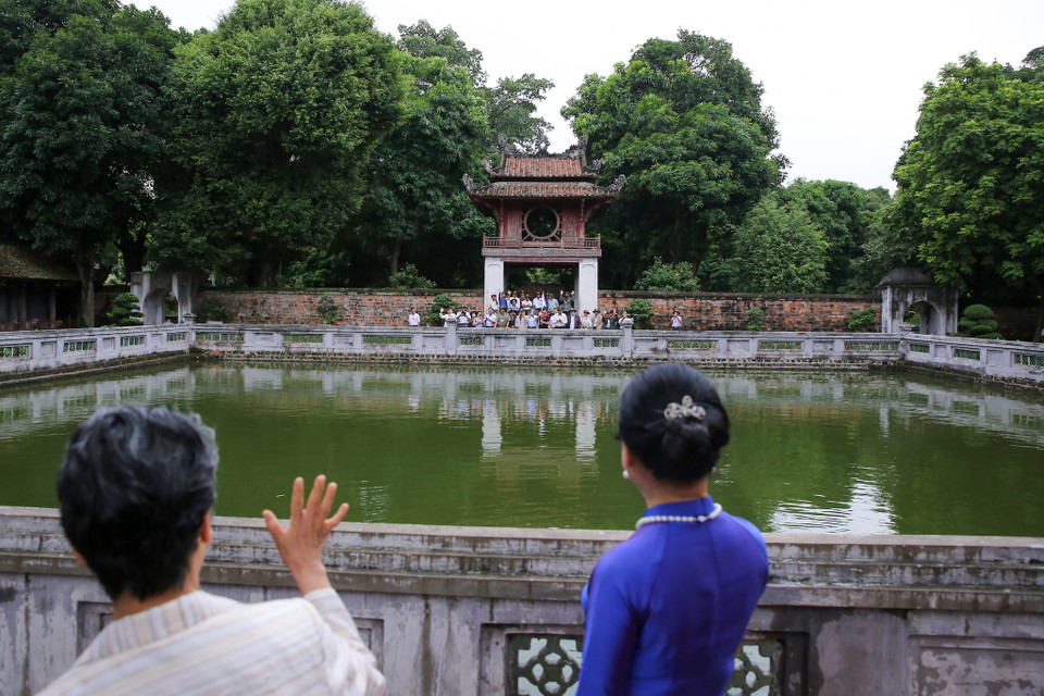 Bà Suga Mariko vẫy tay chào các cựu chiến binh Việt Nam đang tham quan Văn Miếu-Quốc Tử Giám. (Ảnh: Minh Sơn/Vietnam+)