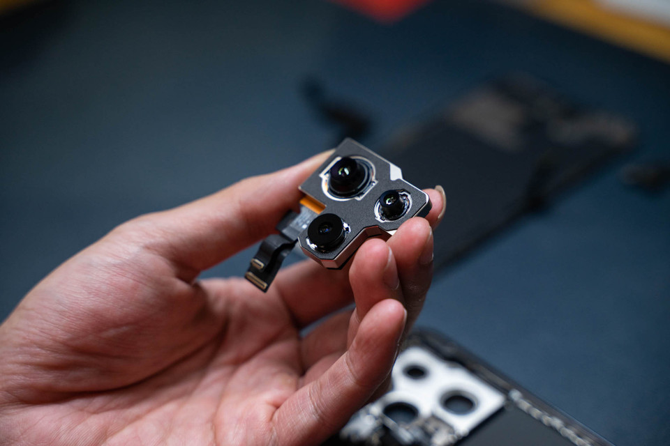 Hệ thống camera trước của iPhone 14 Pro Max sẽ không dễ dàng tháo ra ở lần đầu tiên, do cable được đặt khá kỹ dưới khung, được cố định bằng keo dán. Cụm camera sau đặt gọn trong một bộ khung, do đó kỹ thuật viên có thể tháo chúng ra một cách khá dễ dàng. (Ảnh: Điện Thoại Vui)