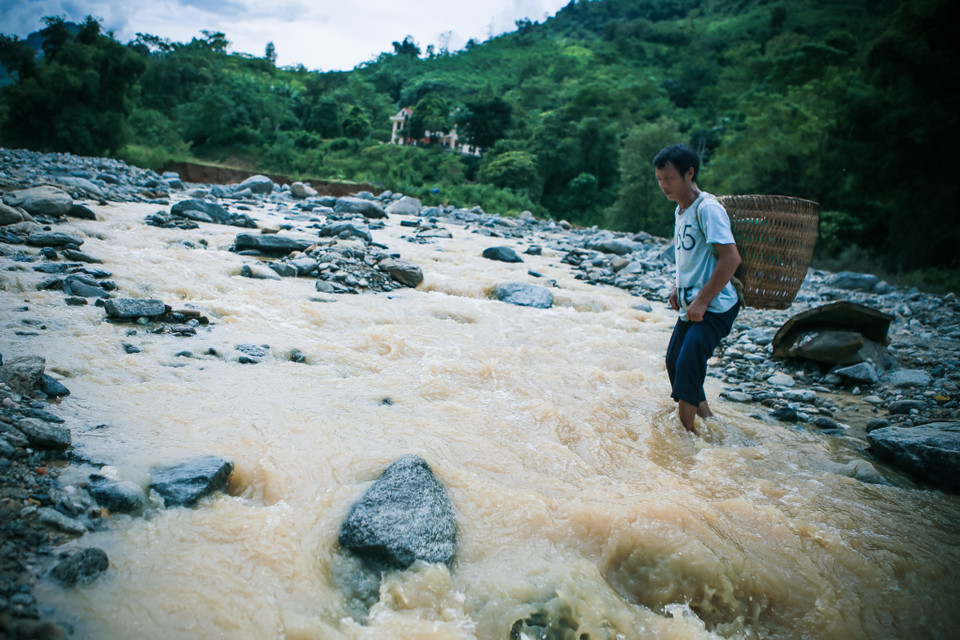 Trước khi một cây cầu tre được dựng tạm lên, những người dân thôn phải lội qua con suối nước chảy xiết đầy nguy hiểm.