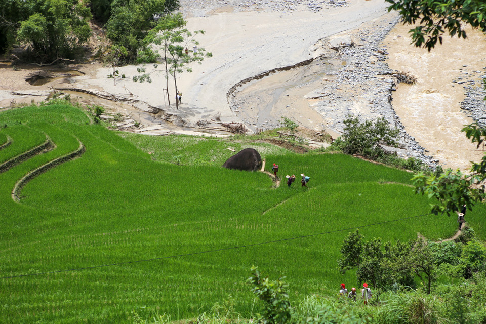 Con đường lên bản bị đất đá vùi lấp khiến đồng bào người Dao nơi đây phải trèo qua các ruộng bậc thang để xuống xã.