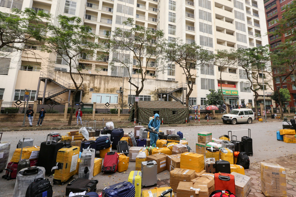 Trước khi tiến hành thủ tục vào nơi cách ly, toàn bộ hành lý tư trang của những người về từ vùng dịch cũng được tiến hành khử khuẩn. (Ảnh: Minh Sơn/Vietnam+)