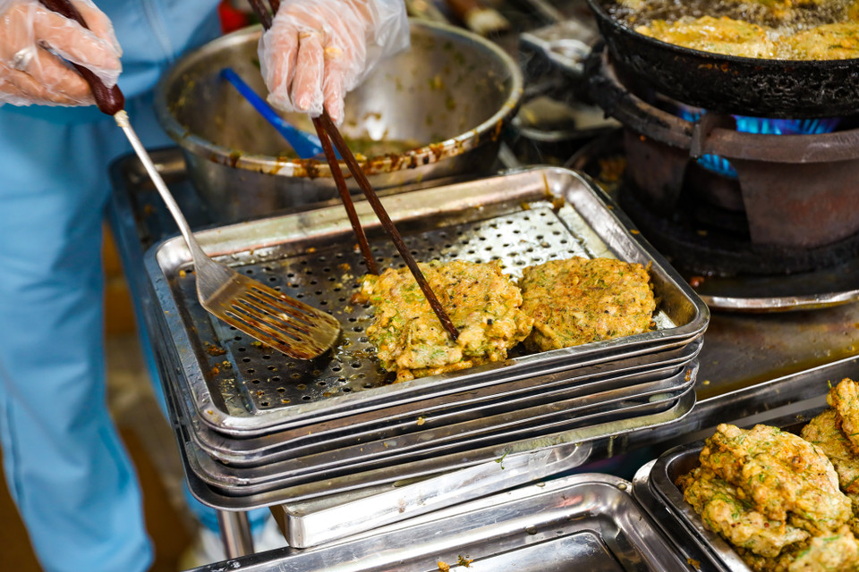 Chả được rán qua một lần, khách gọi ăn hoặc mua về sẽ được rán lại cho nóng. (Ảnh: PV/Vietnam+)