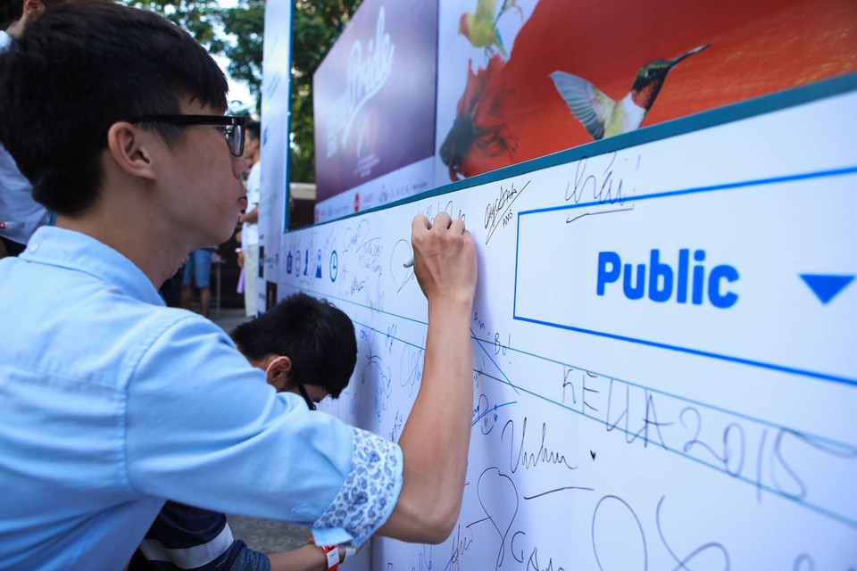 Các bạn trẻ ký tên vào bản cam kết sẽ hết mình ủng hộ cộng đồng LGBT. (Ảnh: Minh Sơn/Vietnam+)