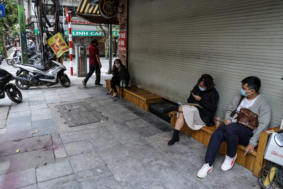 Mặc dù hầu hết các quán xá, hàng ăn đều tuân thủ rất tốt việc đóng cửa phòng, chống dịch COVID-19, nhưng cá biệt vẫn có quán càphê bất chấp lệnh cấm vẫn mở bán cho khách hàng ngồi trên vỉa hè. Hình ảnh ghi nhận vào thời điểm 12 giờ trên đường Nguyễn Hữu Huân. (Ảnh: Minh Sơn/Vietnam+)