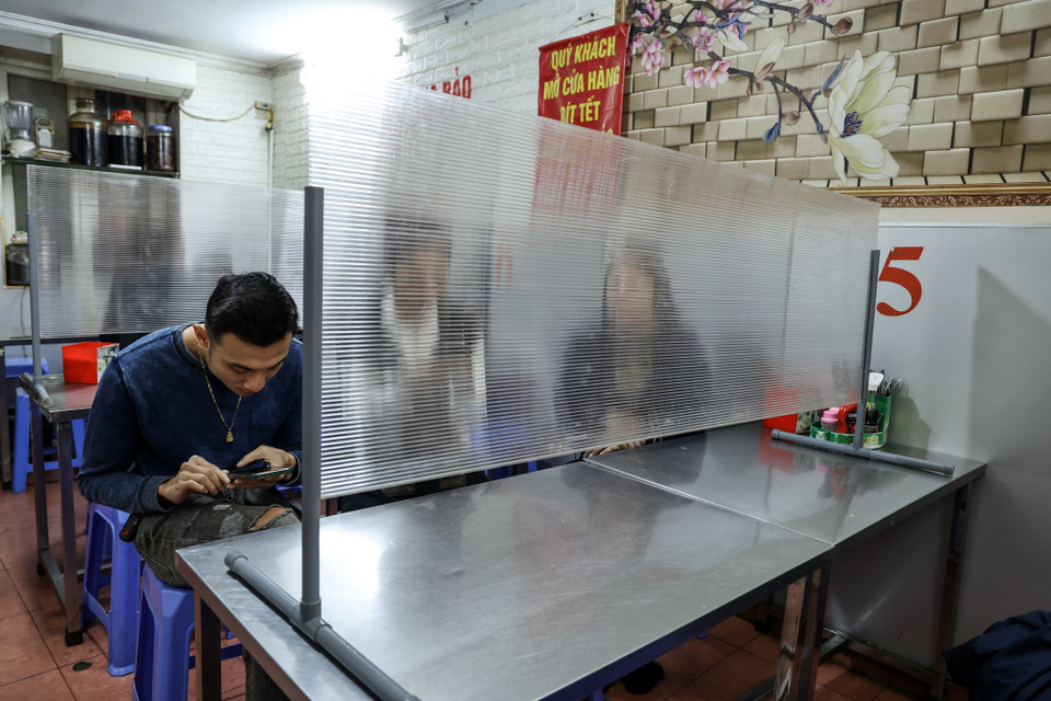 Chị Nguyễn Thị Kim Oanh, chủ một quán ăn trên phố Hoè Nhai cho biết cửa hàng đã cấp tốc lắp màn ngăn cho các thực khách ngồi ngay khi thành phố ra quyết định để đảm bảo an toàn. (Ảnh: Minh Sơn/Vietnam+)