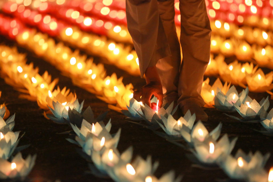 Mỗi ngọn đèn hoa đăng được đốt lên, mỗi người cầu nguyện gửi vào đó một tâm niệm thiện lành, một tâm niệm an lạc cho mình và cho mọi người. Mỗi ngọn đèn trên tay là biểu tượng của ánh sáng xóa hết mọi khổ đau, cùng nhau xây dựng một cuộc sống tươi đẹp. (Ảnh: Minh Sơn/Vietnam+)