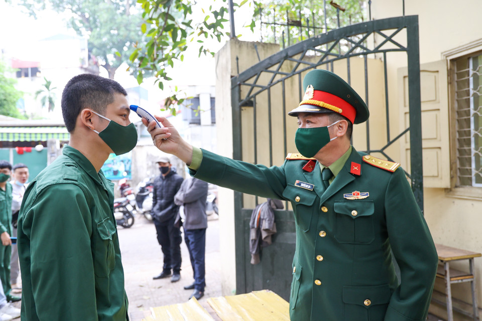 Các tân binh trước khi xét nghiệm đều được đo thân nhiệt và sát khuẩn đầy đủ. (Ảnh: Minh Sơn/Vietnam+)