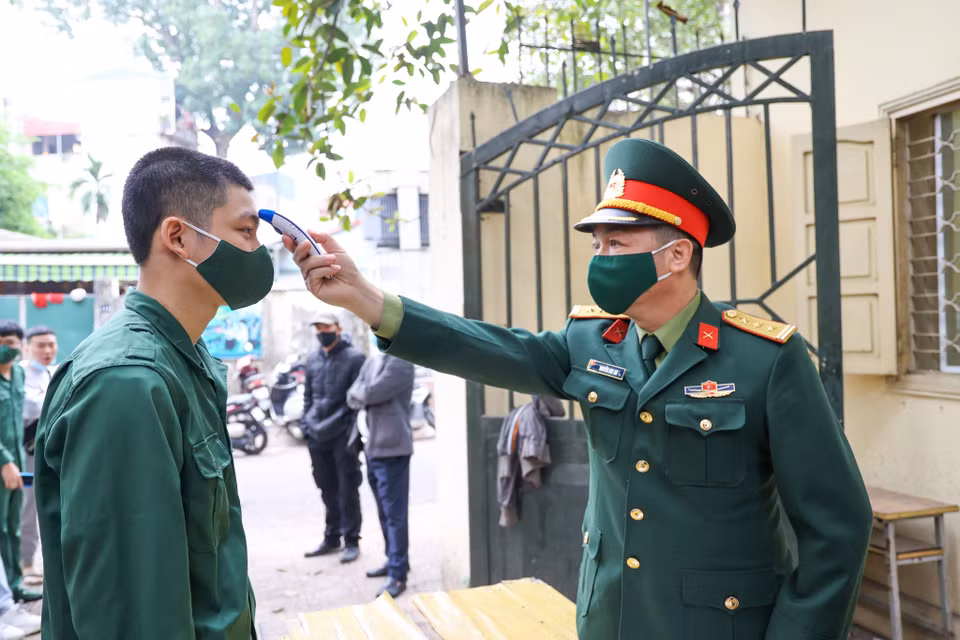 Các tân binh trước khi xét nghiệm đều được đo thân nhiệt và sát khuẩn đầy đủ. (Ảnh: Minh Sơn/Vietnam+)