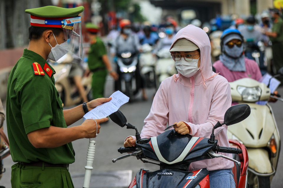 Trên tuyến đường Cầu Diễn (Bắc Từ Liêm, Hà Nội), lực lượng chức năng đã lập hàng rào chia thành 2 làn đường để tiến hành kiểm soát. Ngày hôm nay, Tổ công tác sẽ tiến hành tuyên truyền cho người dân về quy định mới trong Chỉ thị 20 đã áp dụng để chống dịch. (Ảnh: Minh Sơn/Vietnam+)