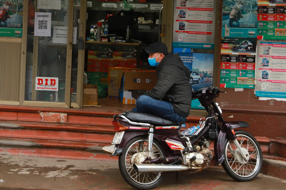 Một số người phải mặc áo khoác khi đi làm do nhiệt độ giảm sâu. (Ảnh: PV/Vietnam+)