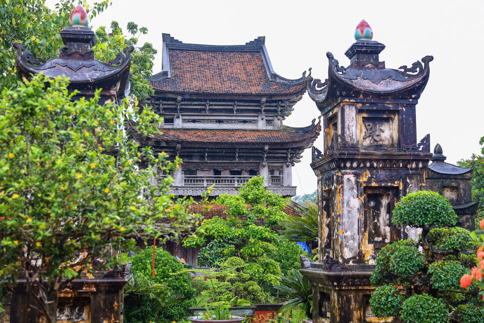 Nổi bật là gác chuông 3 tầng cao hơn 11 mét với bộ khung được kết cấu bởi gần 100 con sơn chồng lên nhau, được gọi là 100 đàn đầu voi liên kết bằng mộng gỗ, nâng đỡ 12 mái ngói cong thanh thoát. (Ảnh: Minh Sơn/Vietnam+)