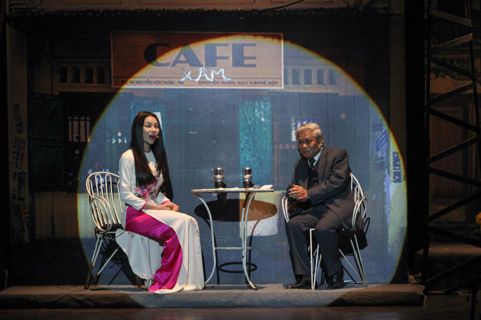 Á hậu Trà Ngọc Hằng dẫn chương trình cùng nhà thơ Vũ Quần Phương trong một không gian tái hiện một quán cà phê đặc trưng những năm 60 của Hà Nội. (Ảnh: Minh Sơn-Hoàng Long/Vietnam+)