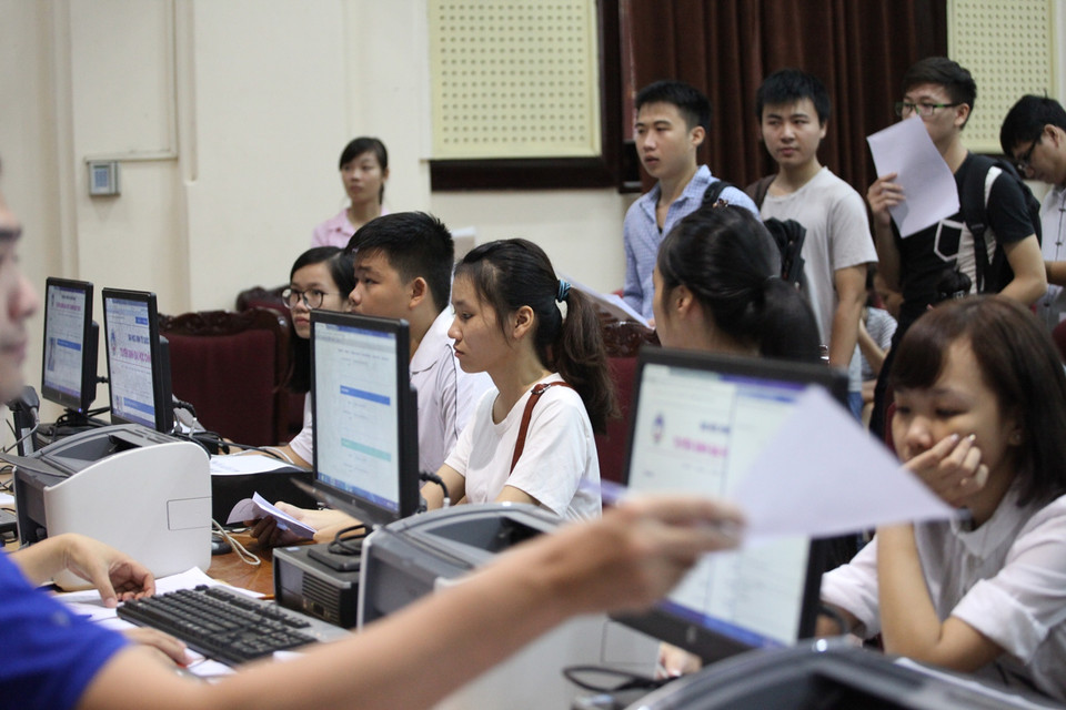 Thí sinh sau khi viết đơn xin rút theo mẫu và có đủ các giấy tờ cần thiết ở phía dưới sẽ lên trên bục, đưa phiếu cho cán bộ hồ sơ biết mình đã đăng ký vào ngành nào, mã hồ sơ bao nhiêu. Chỉ trong khoảng 2 phút, cán bộ hồ sơ sẽ tìm ra và trả lại cho thí sinh. (Ảnh: PV/Vietnam+)