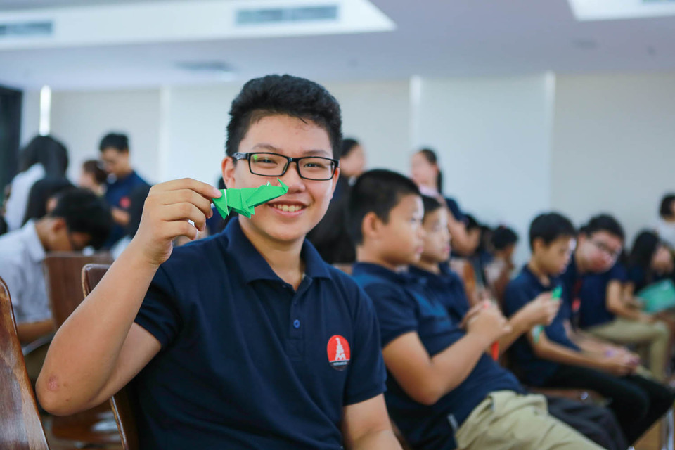 Một bạn học sinh thích thú khoe chú tê giác vừa gấp xong. (Ảnh: Minh Sơn/Vietnam+)