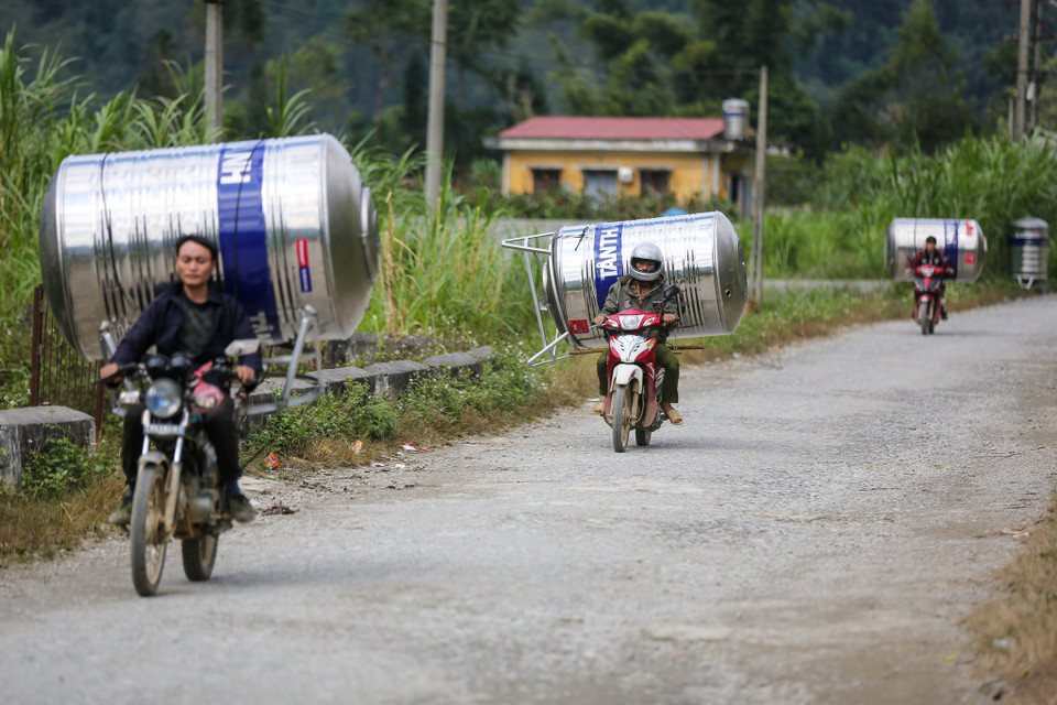 Đường tới thôn Lủng Sính tương đối khó khăn, ôtô không thể tới được nên những bồn nước còn được vận chuyển bằng xe máy. (Ảnh: Minh Sơn/Vietnam+)