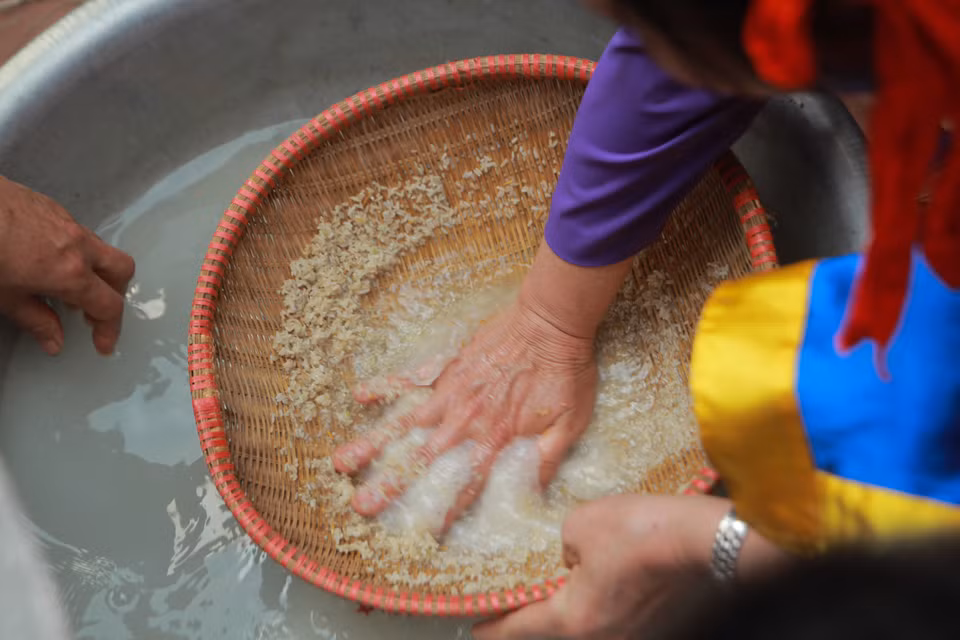 Có 4 đội thổi cơm thi mỗi đội được cử 10 nam nữ dự thi: 4 người xay thóc giã gạo, một người dần sàng, một người lấy nước, hai người kéo lửa bằng cây giang, hai người thổi cơm. (Ảnh: Minh Sơn/Vietnam+)