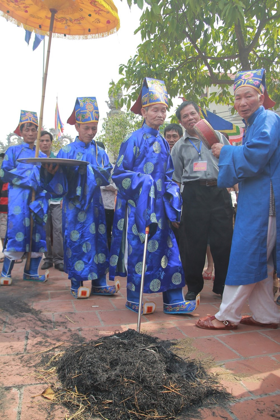 Các quan sẽ đi dò nồi cơm được vùi trong tro rơm. (Ảnh: Minh Sơn/Vietnam+)