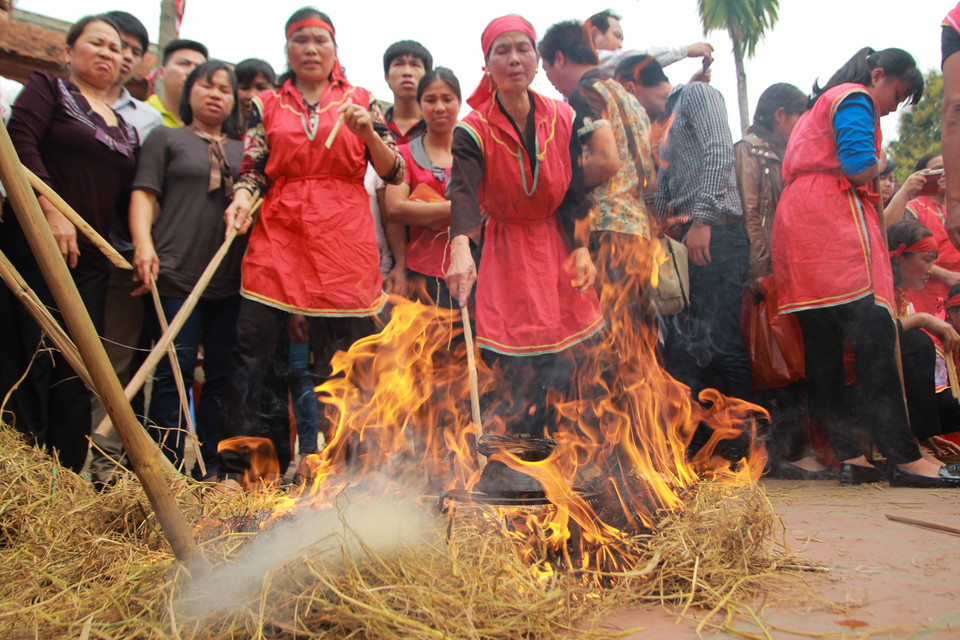 Để kéo dài thời gian cho cơm chín nục, các đội sẽ phải đốt vun nhiều đống tro rơm để ủ cơm trong đống tro. (Ảnh: Minh Sơn/Vietnam+)