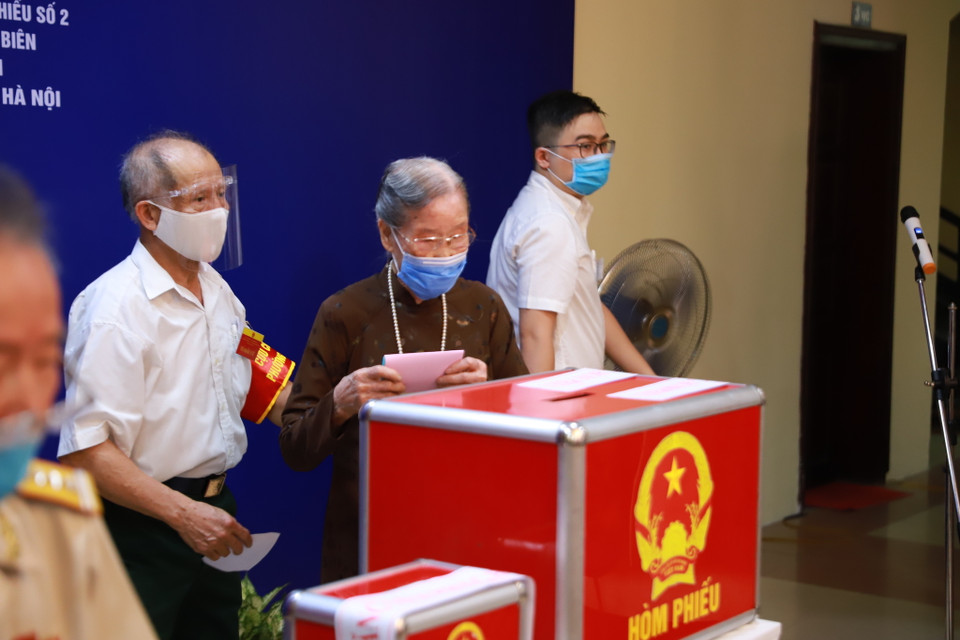 Cụ Đoàn Thị Thuận tự tay bỏ tấm phiếu bầu cử đầu tiên để thực hiện quyền công dân. (Ảnh: Hoài Nam/Vietnam+)