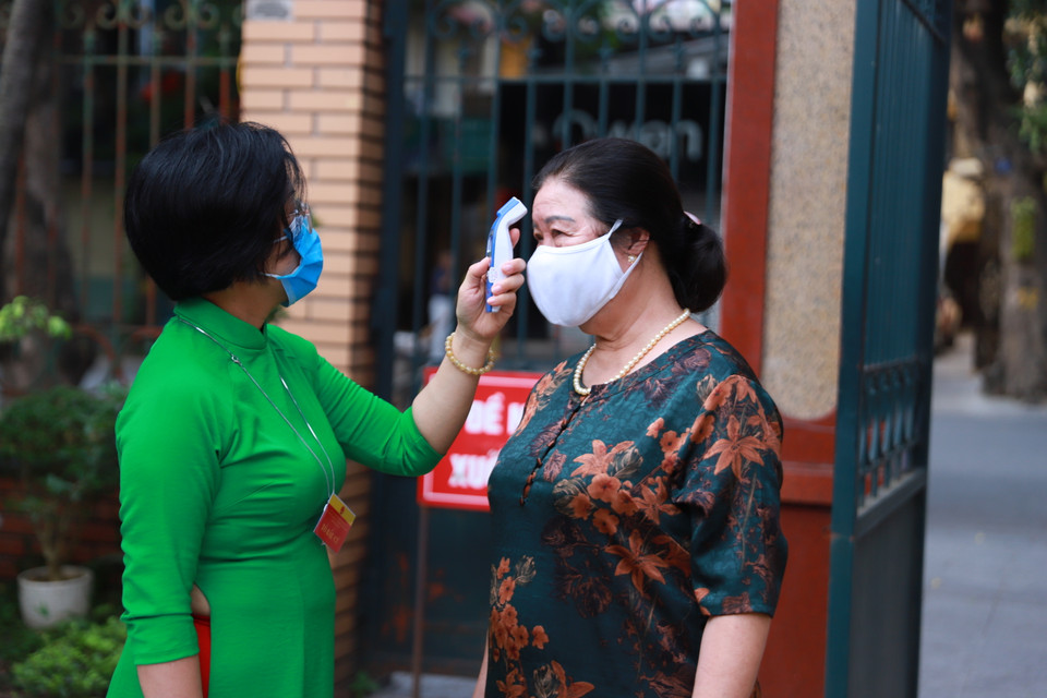 Điểm bỏ phiếu thực hiện nghiêm các quy tắc phòng chống dịch như đo thân nhiệt và khử khuẩn trước khi vào khu vực bỏ phiếu. (Ảnh: Hoài Nam/Vietnam+)