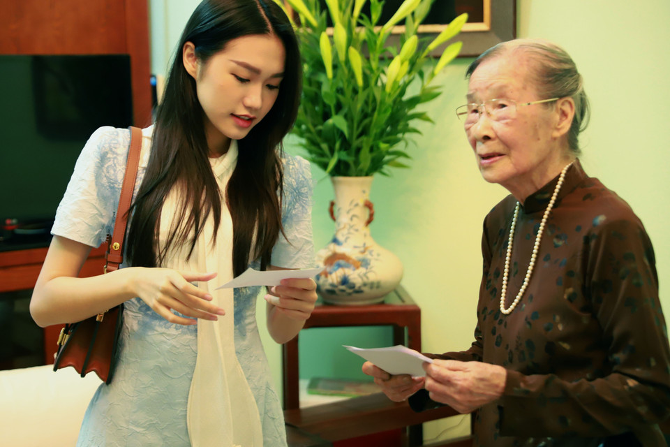 Bà Thuận phát phiếu cử tri cho từng thành viên trong gia đình. Đặc biệt là chắt của cụ Doãn Hải My (sinh năm 2001), đây cũng là lần đầu tiên trong đời My được đi bỏ phiếu thực hiện quyền công dân. (Ảnh: Hoài Nam/Vietnam+)