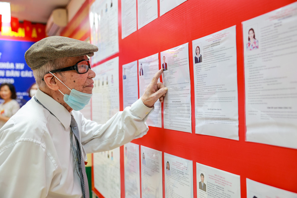 Dù tuổi đã cao, lưng đã còng nhưng ông Ca luôn theo dõi sát sao danh sách các cử tri để lựa chọn những đại biểu xứng đáng nhất. (Ảnh: Minh Sơn/Vietnam+)