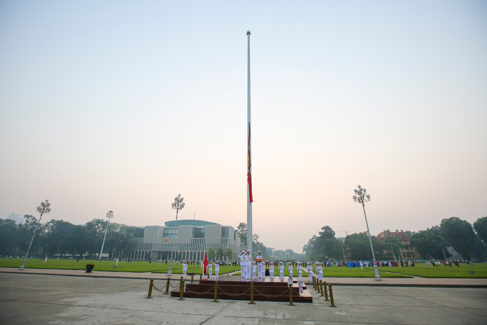 Nghi lễ treo băng tang được tiến hành song song với nghi thức chào cờ hàng ngày vẫn diễn ra trên Quảng trường Ba Đình. (Ảnh: Minh Sơn/Vietnam+)