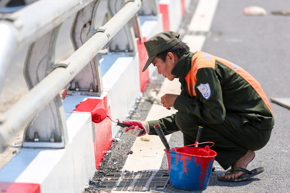 Theo kế hoạch, ngày 30/9, các hạng mục còn lại của dự án như trải thảm bêtông nhựa mịn phần cầu và đường, lắp đặt lan can thép, chiếu sáng trên cầu, trồng cây xanh vỉa hè đang được hoàn thành. (Ảnh: Minh Sơn/Vietnam+)