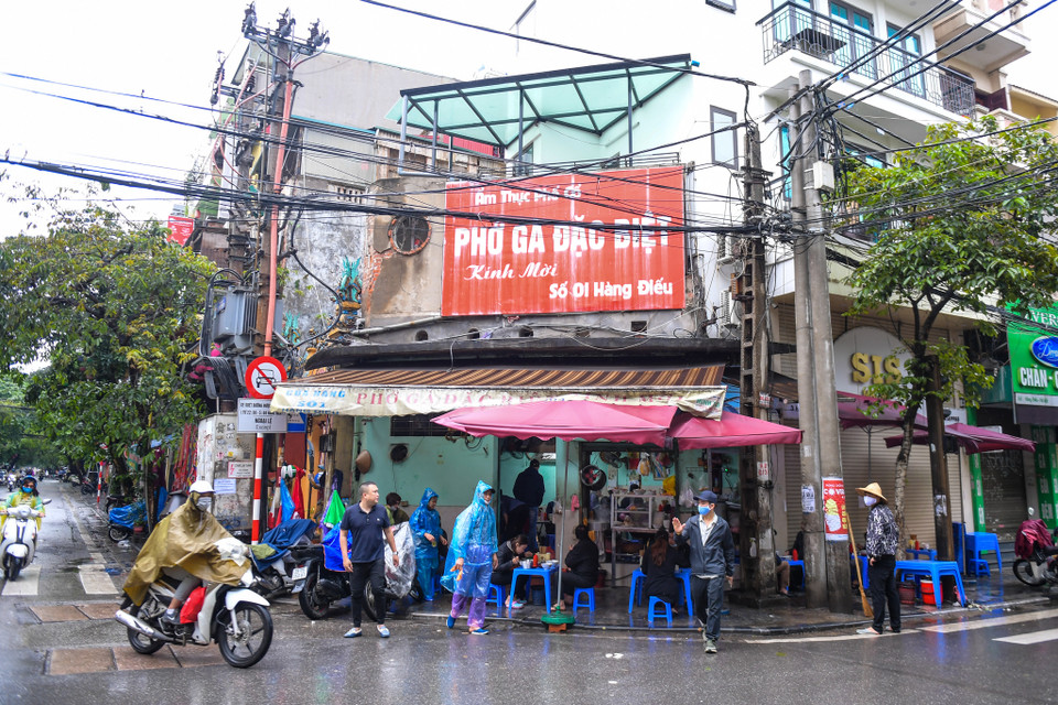 Cơn mưa lớn vào sáng 24/4 cũng không ngăn được nhiều người dân tìm đến thưởng thức một trong những nét ẩm thực đặc biệt của Hà Nội. (Ảnh: PV/Vietnam+)