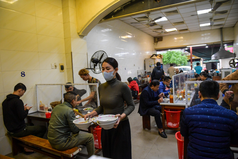 Các khách hàng khi đến cửa hàng này ăn đều được yêu cầu rửa tay sát trùng và phải ngồi cách xa nhau. (Ảnh: PV/Vietnam+)