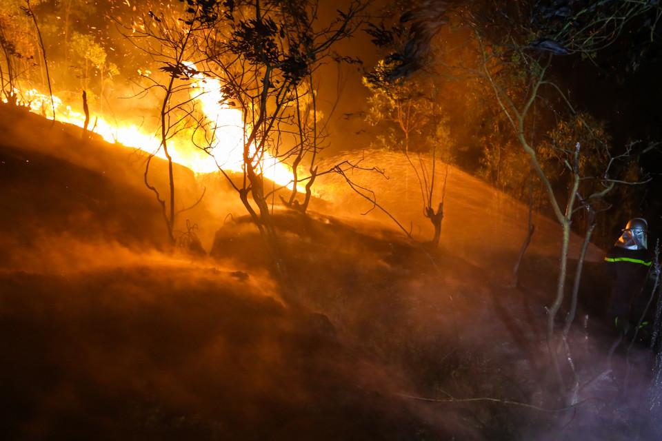 Trong chiều và tối 5/6, có khoảng 20 hộ dân trên địa bàn xã Nam Sơn phải tiến hành sơ tán. Nhiều xe chữa cháy được tập trung ở chân núi, chủ yếu để bảo vệ an toàn cho nhà dân. (Ảnh: PV/Vietnam+)