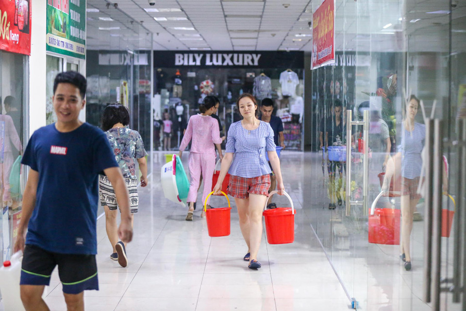 Thời điểm 12h đêm nhưng cả tòa chung cư vẫn tấp nập người dân tranh thủ đi lấy nước. (Ảnh: Minh Sơn/Vietnam+)