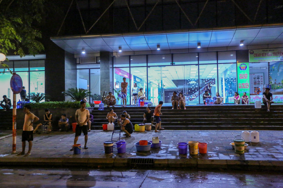 Ngay trong đêm 16 rạng sáng 17/10, hàng trăm hộ dân tại tòa nhà Gemek Tower (Hoài Đức, Hà Nội) đã mang theo xô, chậu tấp nập xếp hàng, chờ đến lượt nhận nước sạch về sinh hoạt. (Ảnh: Minh Sơn/Vietnam+)