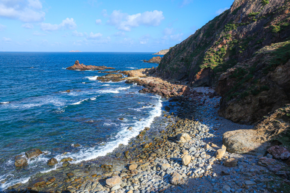 Nếu chịu khó khám phá, du khách có thể đi sâu xuống dưới Eo Gió. Trước mặt du khách sẽ hiện ra một bãi biển tuyệt đẹp. (Ảnh: Minh Sơn/Vietnam+)