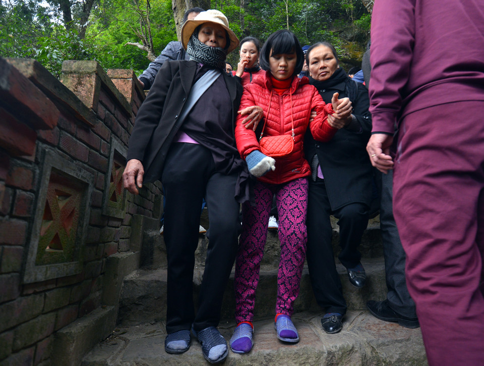 Chị Giang ở Lảnh Giang, bị tai biến khó khăn trong đi lại nhưng người thân vẫn dễ dàng dìu đi. (Ảnh: CTV/Vietnam+)