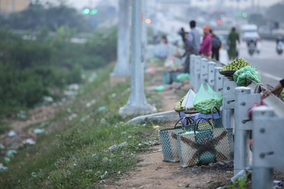 Nhưng mỗi khi thấy bóng dáng lực lượng chức năng, người bán lại nhanh tay giấu số hàng hóa của mình vào sau hàng rào chắn. (Ảnh: Minh Sơn/Vietnam+)